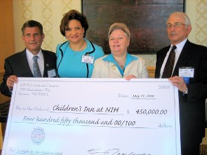 Ken Touloumes, chapter president (r), and Robert Guerra, gala co-chair, presented the proceeds from the chapter's annual gala to Dr. Lauren Wood (l), chair of The Children's Inn at NIH board of directors, and Kathy Russell, CEO, The Children's Inn at NIH.